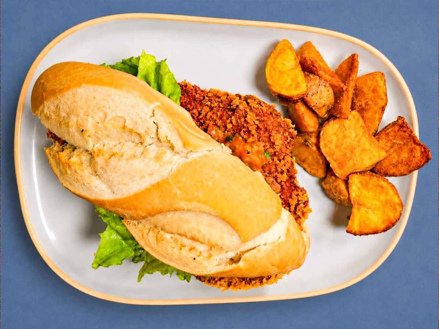 Petite baguette de pollo con papas quebradas