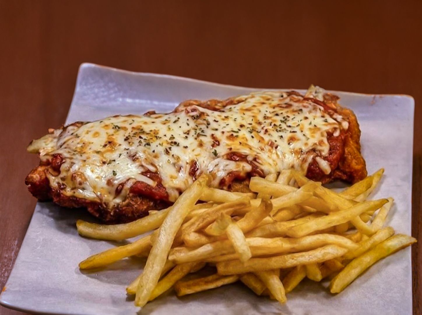 Suprema a la pizza con papas fritas