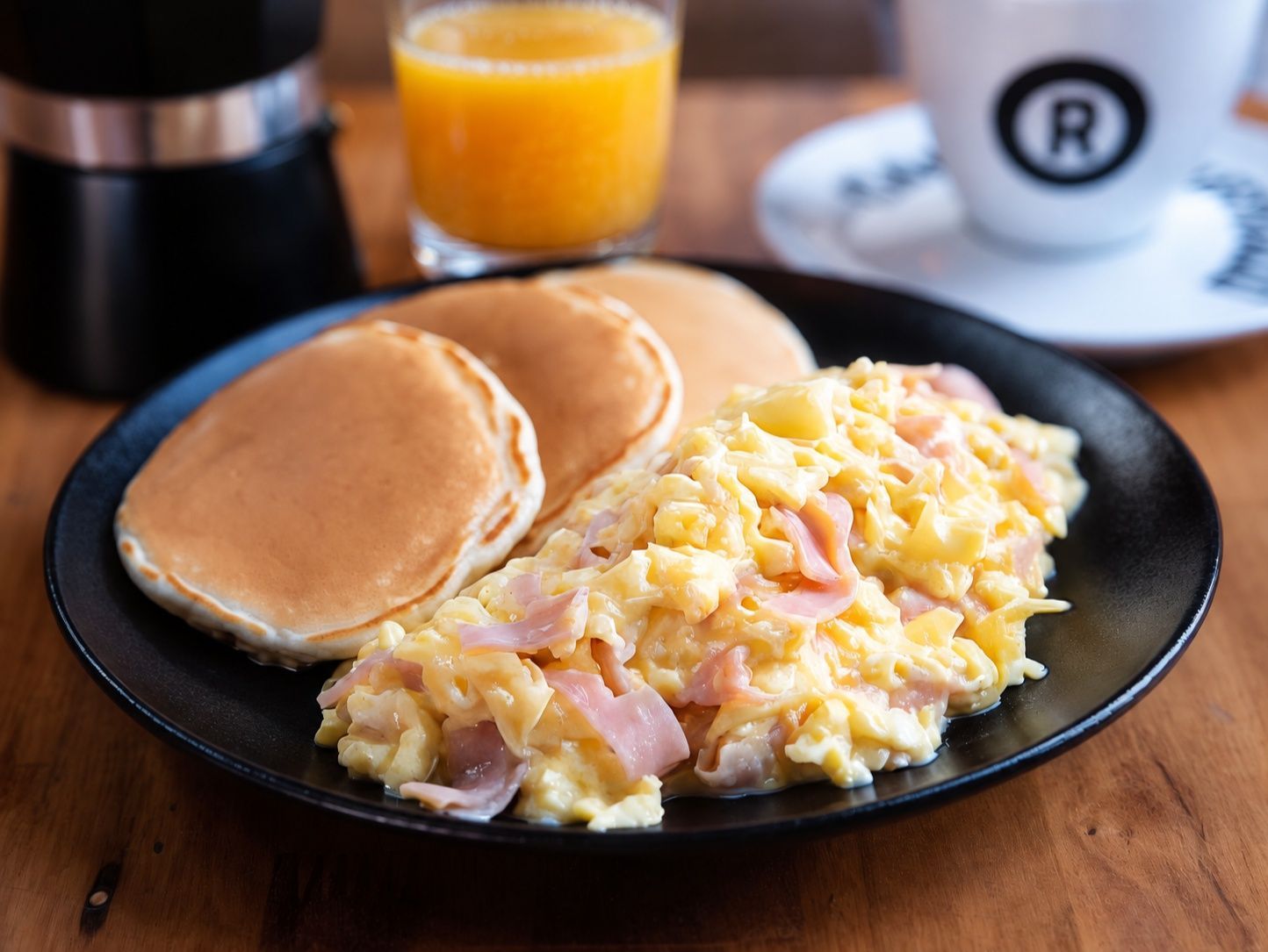Huevos revueltos + pancakes + jugo exprimido