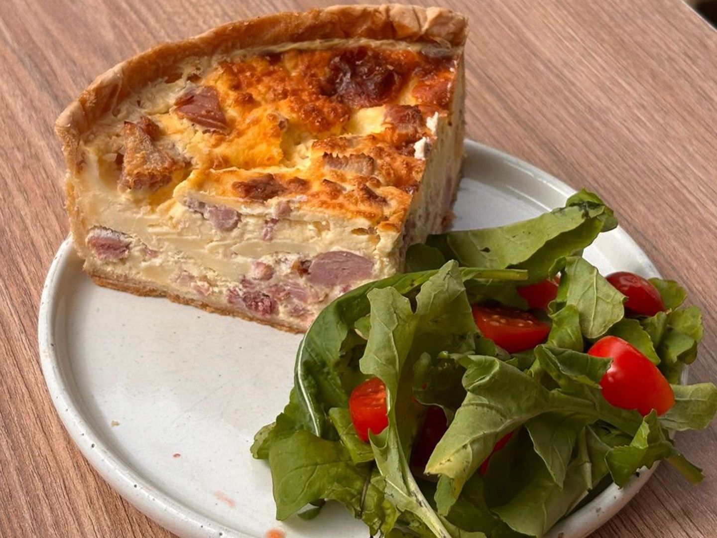 Porción de tarta con ensalada.